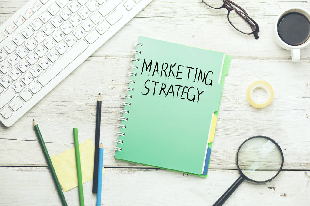 marketing strategy text on notebook with computer keyboard and  stationary - Photo, Image