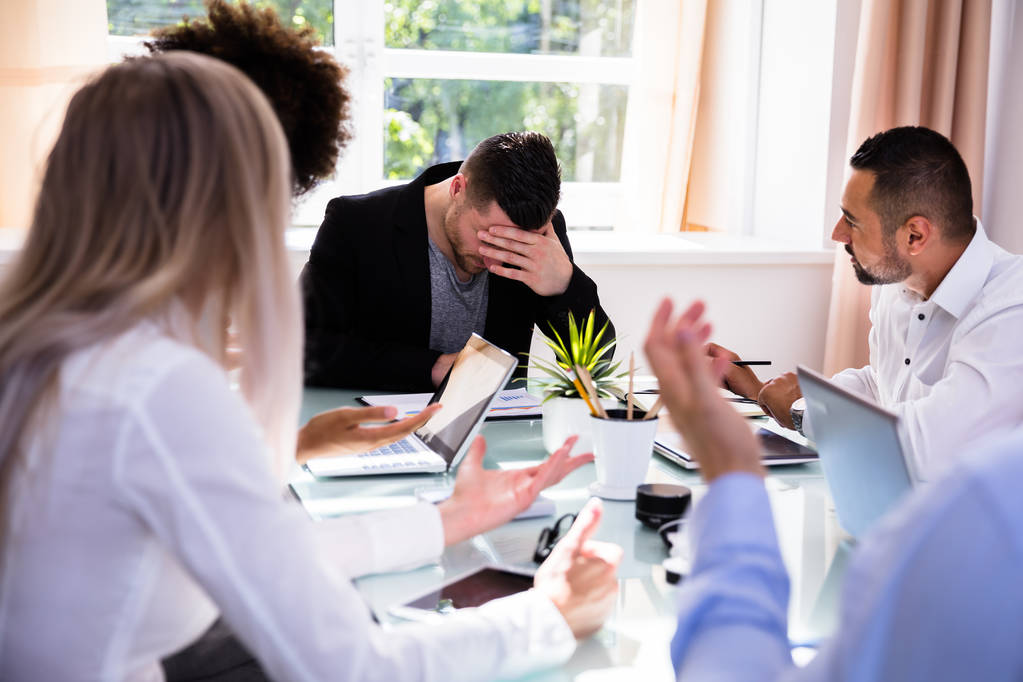 Businesspeople Blaming Their Depressed Young Male Colleague In Office - Photo, Image