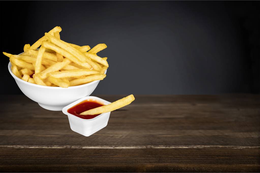 sült krumpli ketchuppal a fa asztalon  - Fotó, kép