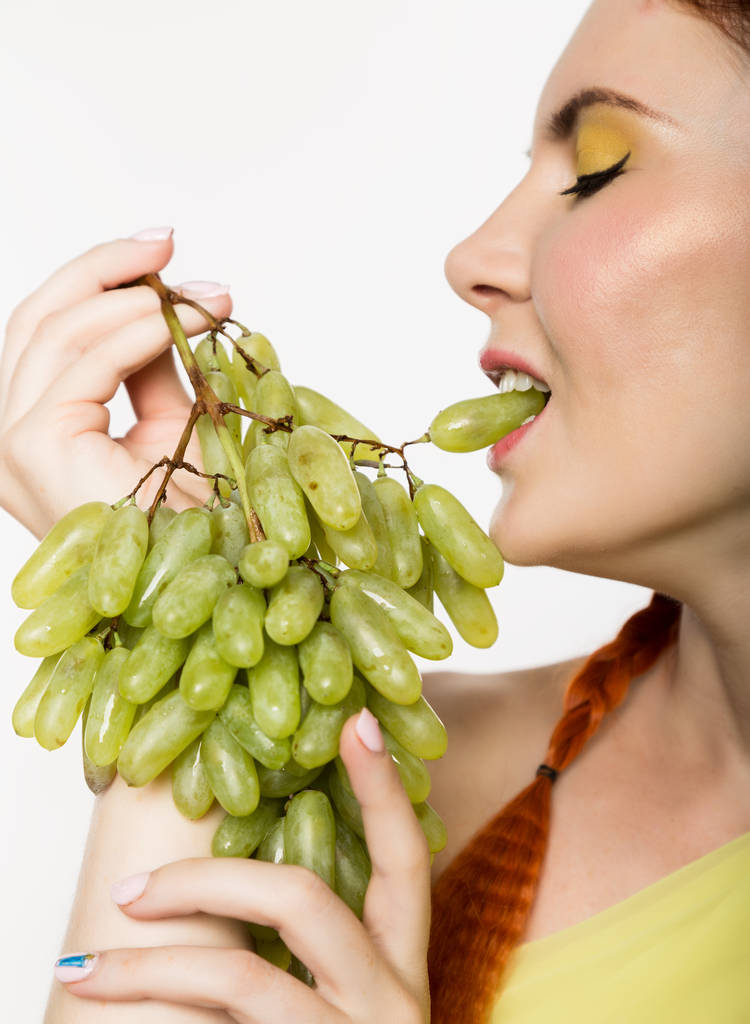 Красива руда жінка їсть виноград. концепція здорового харчування
 - Фото, зображення