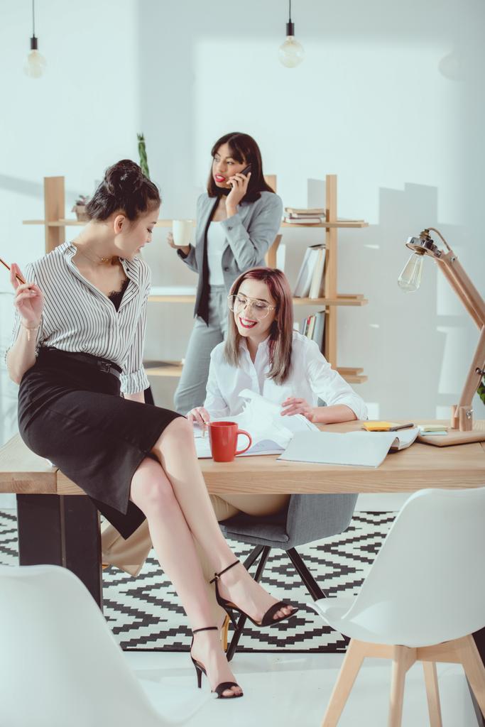 Többnemzetiségű csoport vonzó fiatal üzletasszonyok formális viselni dolgozik együtt a modern iroda - Fotó, kép