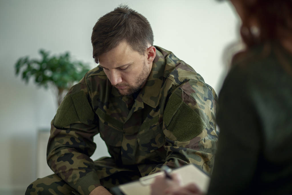 Солдат сидит и разговаривает со своим терапевтом - Фото, изображение