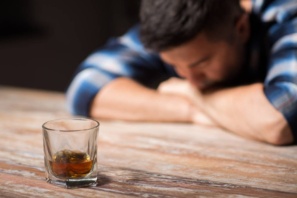 п'яний чоловік зі склянкою алкоголю на столі вночі
 - Фото, зображення