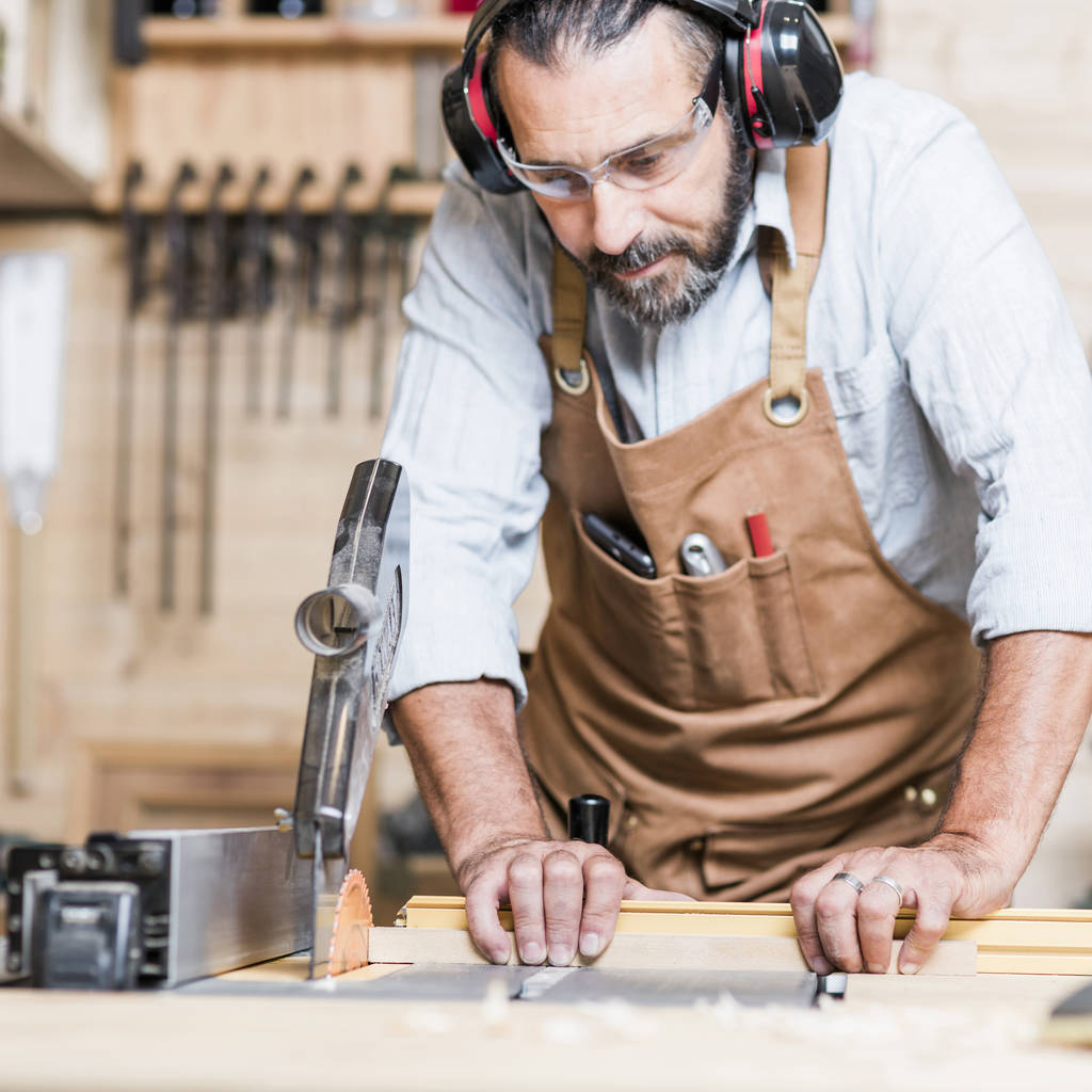 kaukázusi carpenter a munkahelyen, műhelyben, asztali körfűrész - Fotó, kép