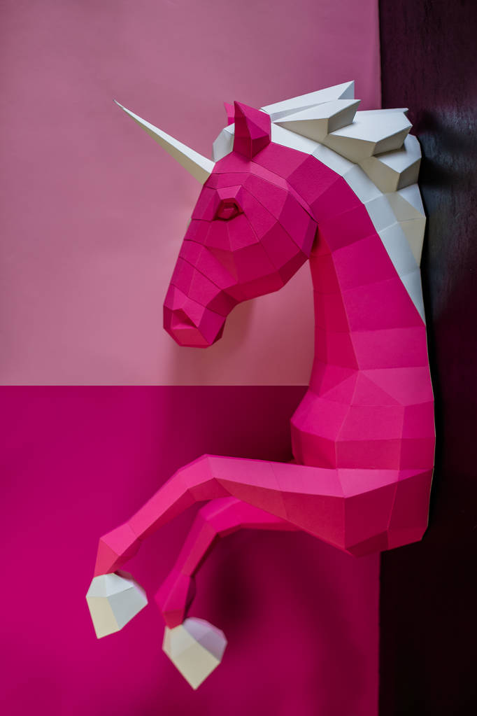 Cabeza de un unicornio de papel sobre fondo rosa y azul
. - Foto, Imagen
