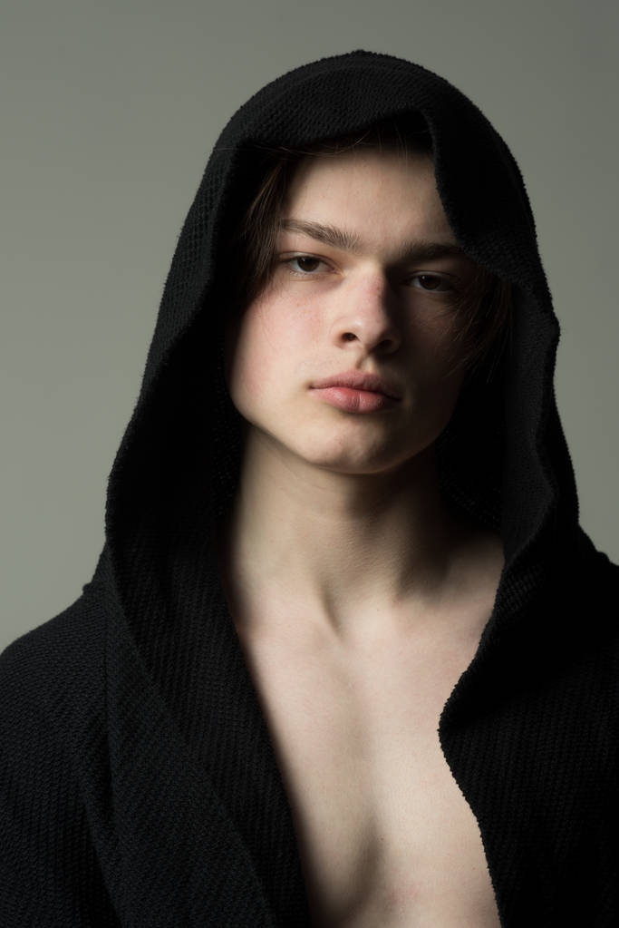 man. man in hood clothes. stylish man in black. cool and trendy. fashion model man with soft skin - Photo, Image