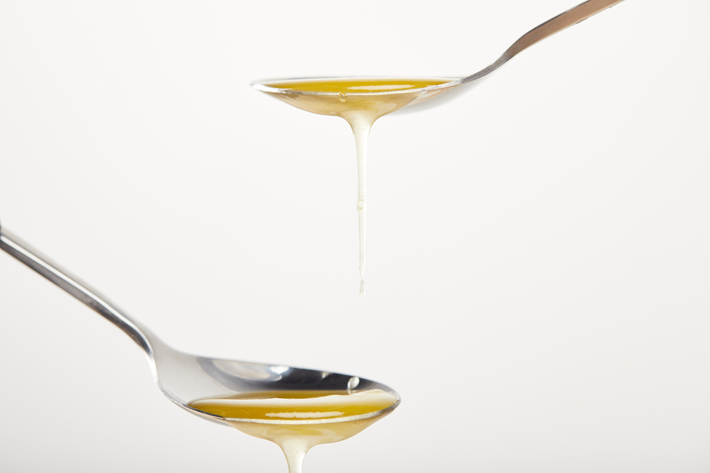 lähikuva lusikat hunajaa valkoisella pohjalla
 - Valokuva, kuva