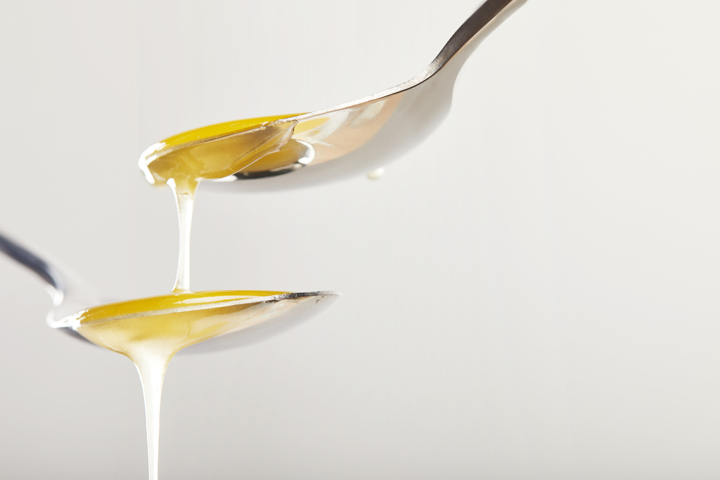 lähikuva lusikat hunajaa harmaalla pohjalla
 - Valokuva, kuva