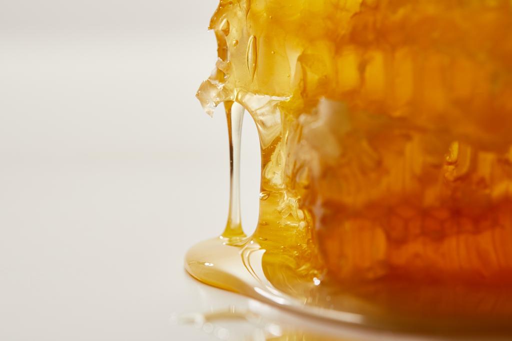 vista de cerca de la cera de abeja dulce y la miel sobre fondo blanco
 - Foto, imagen