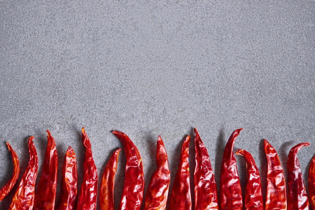 вид сверху на сушеный красный перец чили, расположенный на сером столе
 - Фото, изображение