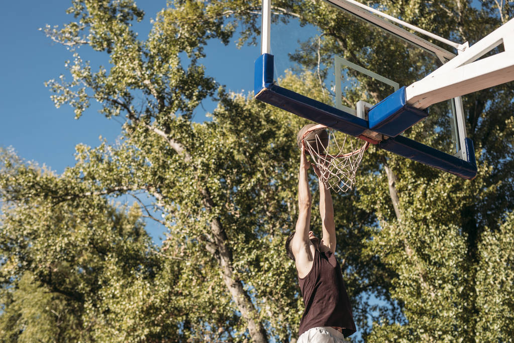 Basketbalový hráč střílí na venkovní kurt. - Fotografie, Obrázek