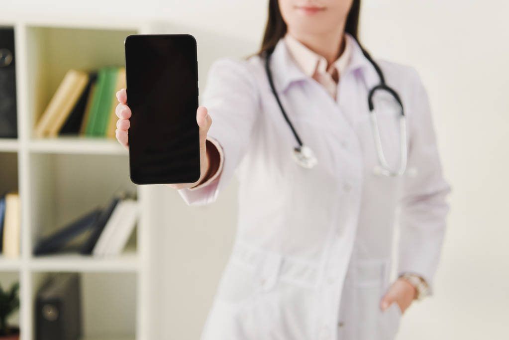cropped view of doctor showing smartphone with blank screen - Photo, Image