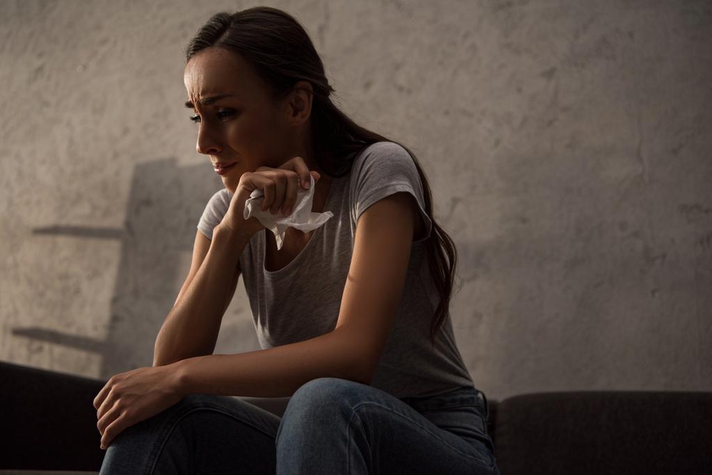 smutná žena držící ubrousek a pláč v žalu a sedí doma - Fotografie, Obrázek