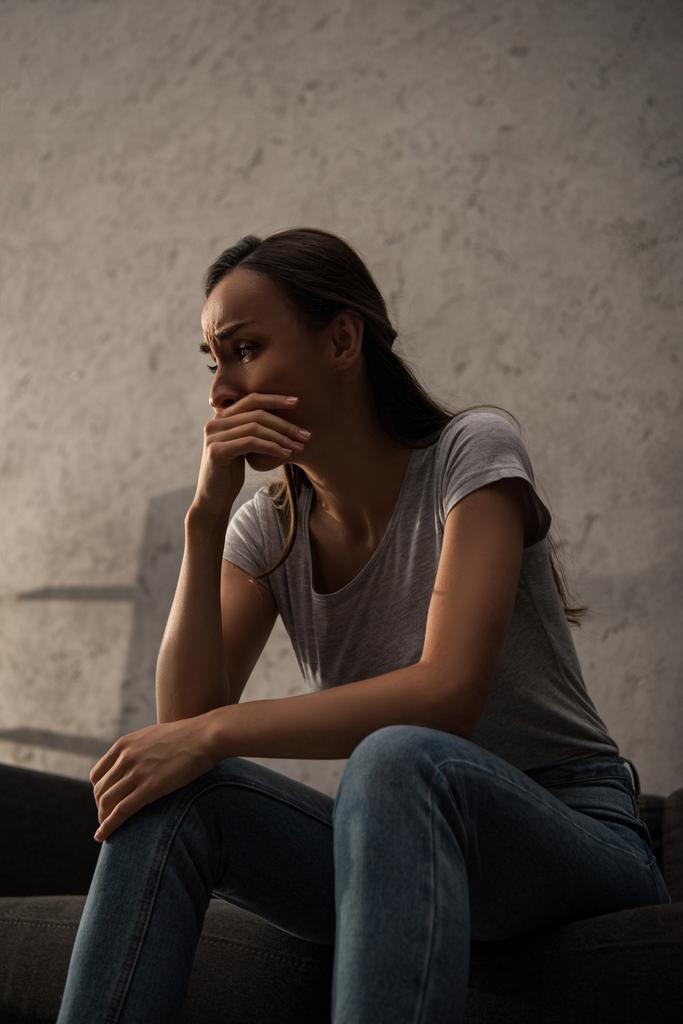 järkyttynyt itkevä nainen istuu sohvalla
  - Valokuva, kuva