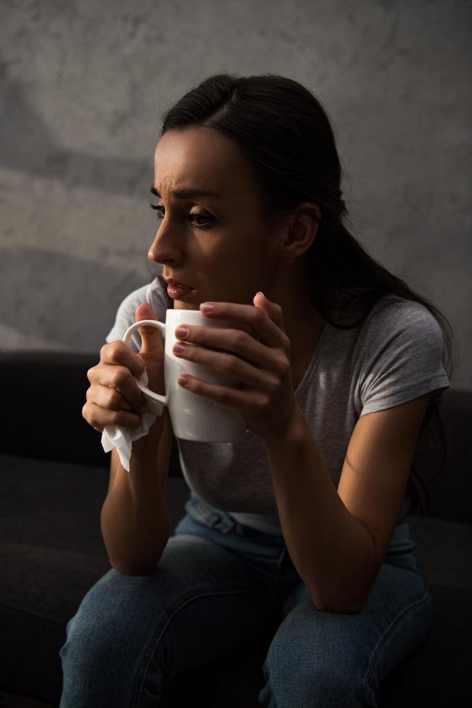 一杯のコーヒーを保持している孤独な悲しい女性   - 写真・画像