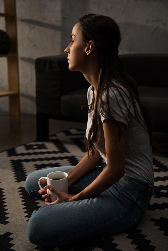 upset lonely woman with cup of coffee sitting on floor - Photo, Image