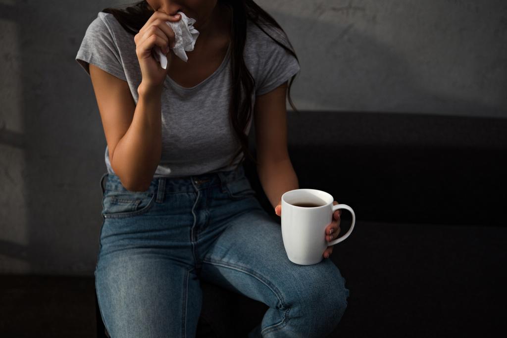 przycięte widzenia zdenerwowany kobietę serwetka i filiżankę kawy - Zdjęcie, obraz