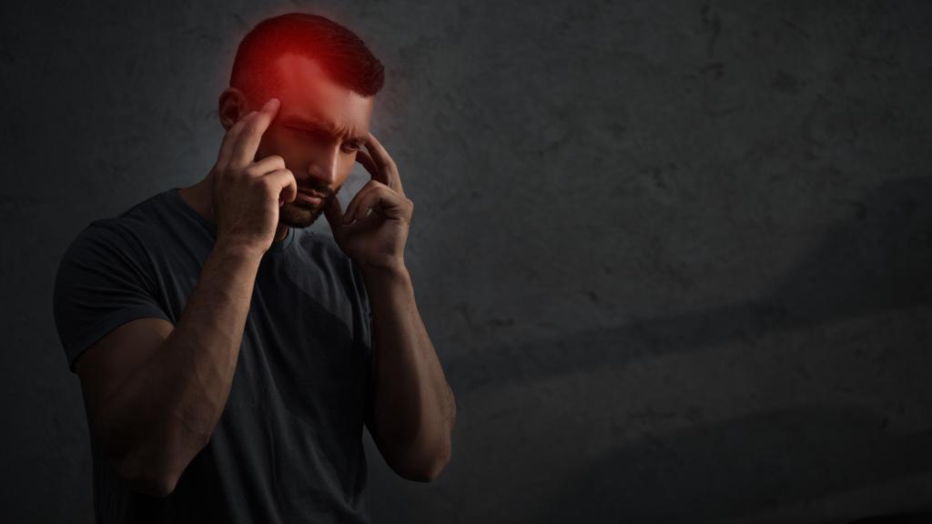 Müder verärgerter Mann leidet unter Kopfschmerzen mit rotem schmerzhaften Punkt am Kopf - Foto, Bild