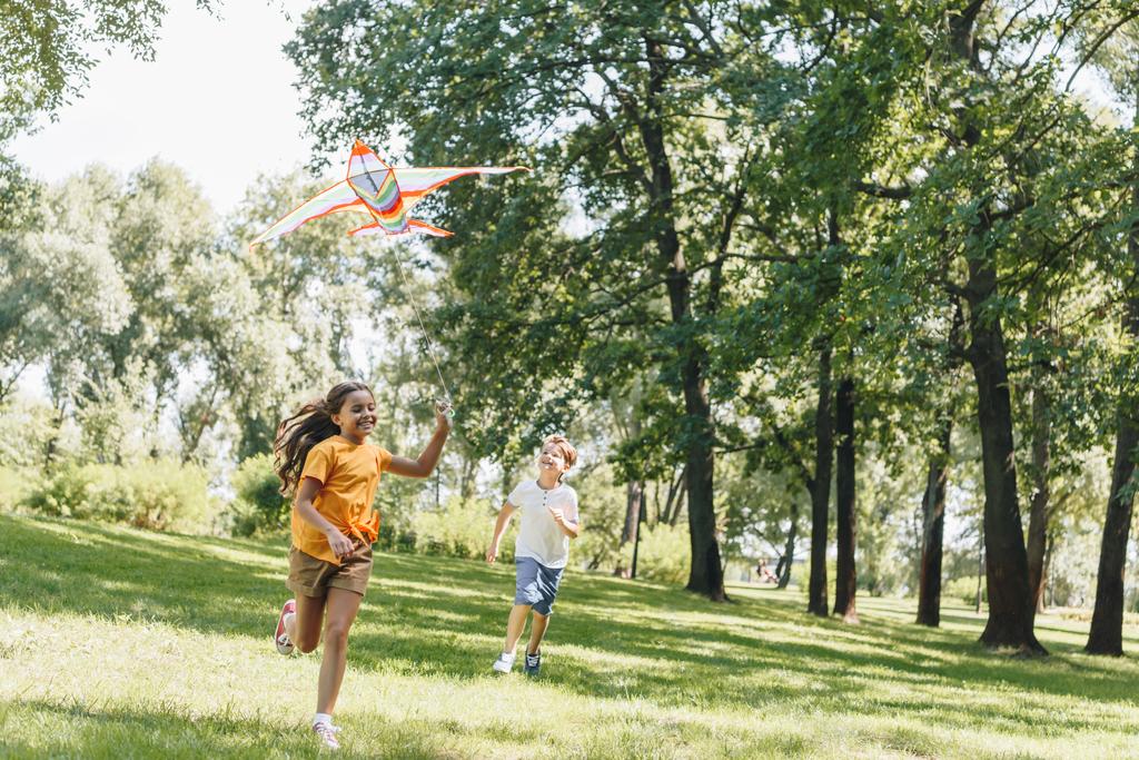 carino bambini felici che giocano con aquilone colorato nel parco
   - Foto, immagini
