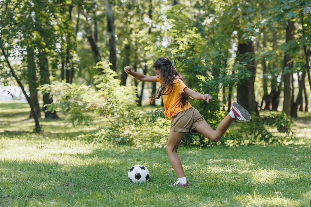 Çocuk park futbol topu tekmeleme yan görünüm - Fotoğraf, Görsel