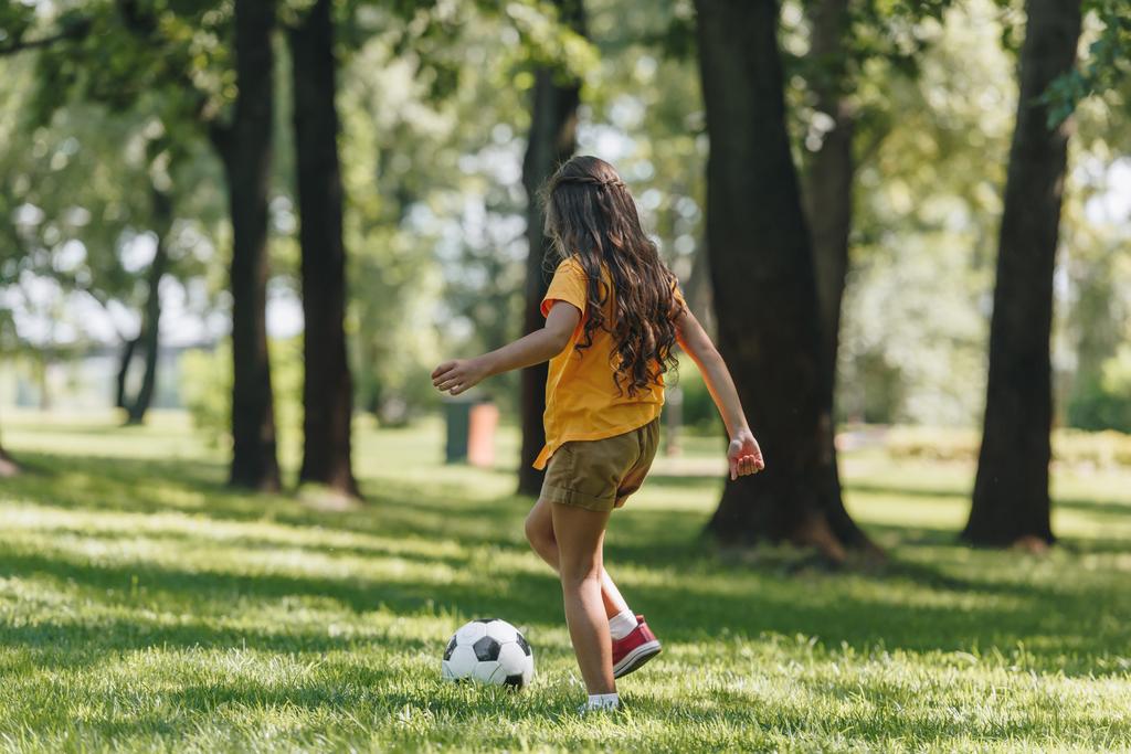 volle Länge Ansicht von niedlichen Kind spielen mit Fußball auf Gras  - Foto, Bild