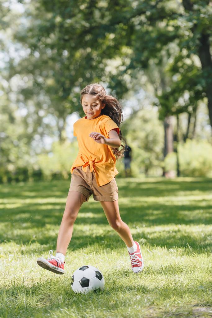 entzückend lächelndes Kind spielt mit Fußball im Park  - Foto, Bild