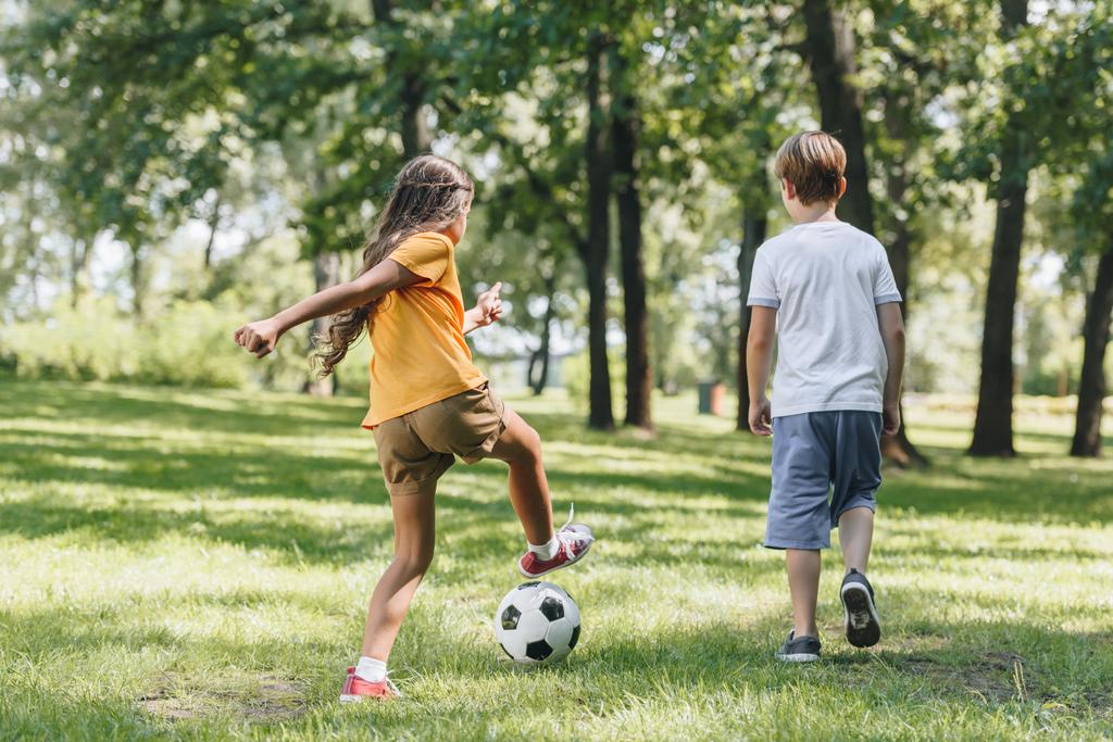 arkadan görünüşü ile futbol topu parkta oynayan çocuklar - Fotoğraf, Görsel