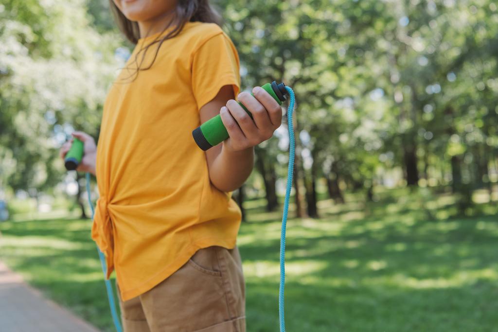 cropped shot of child holding skipping rope in park - Photo, Image