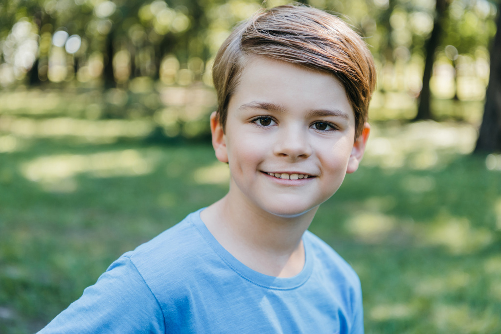 портрет щасливого маленького хлопчика, який посміхається на камеру в парку
 - Фото, зображення