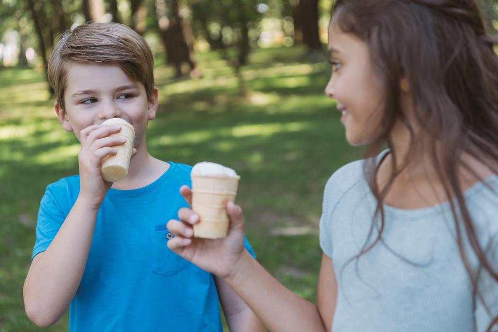 χαριτωμένα παιδιά χαμογελαστά τρώει παγωτό στο πάρκο - Φωτογραφία, εικόνα