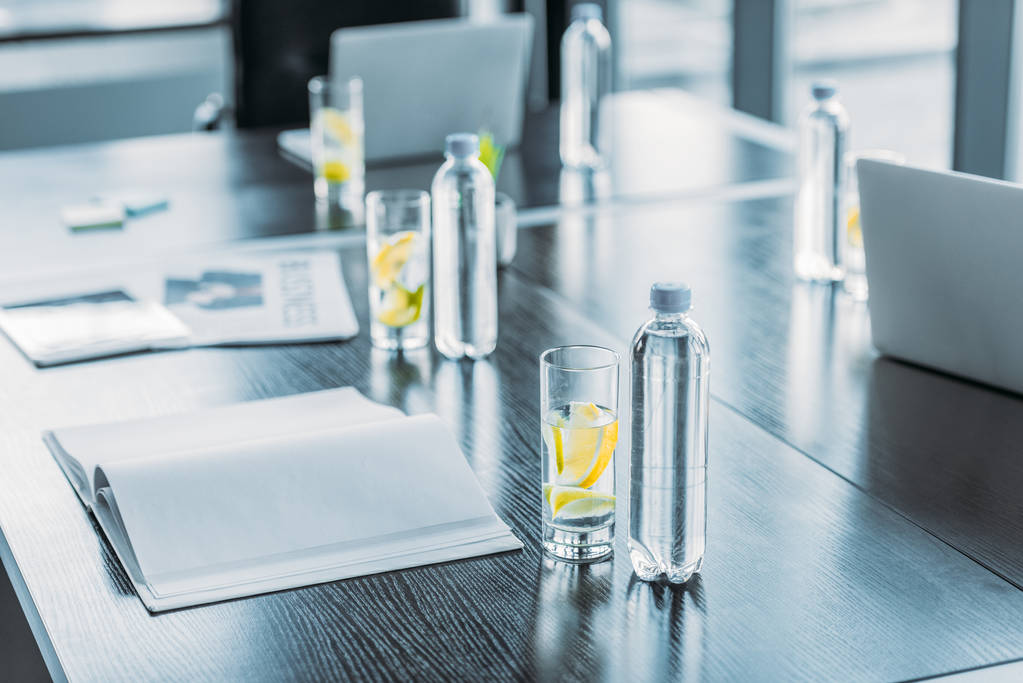 bottles and glasses with antioxidant drink for business meeting on table in workspace - Photo, Image