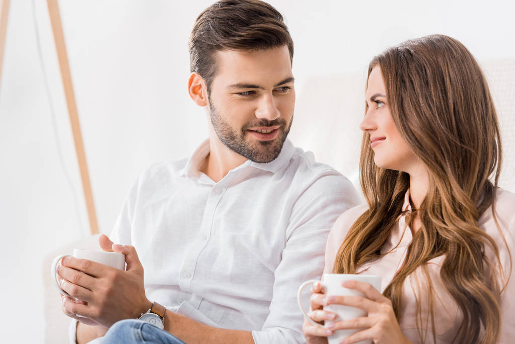 portrait of young loving couple with cups of coffee at home - Photo, Image