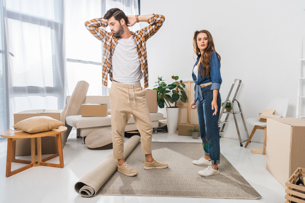 confused young couple at new house with cardboard boxes, moving home concept - Photo, Image