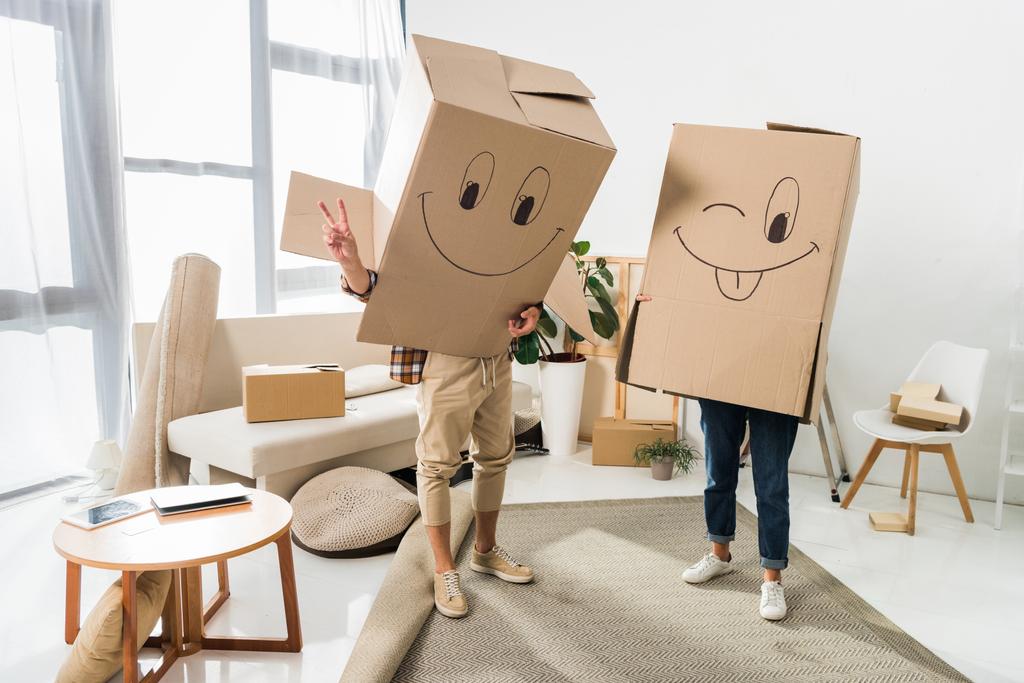 vista oscurecida de pareja con cajas de cartón en cabezas en casa nueva, concepto de casa móvil
 - Foto, Imagen
