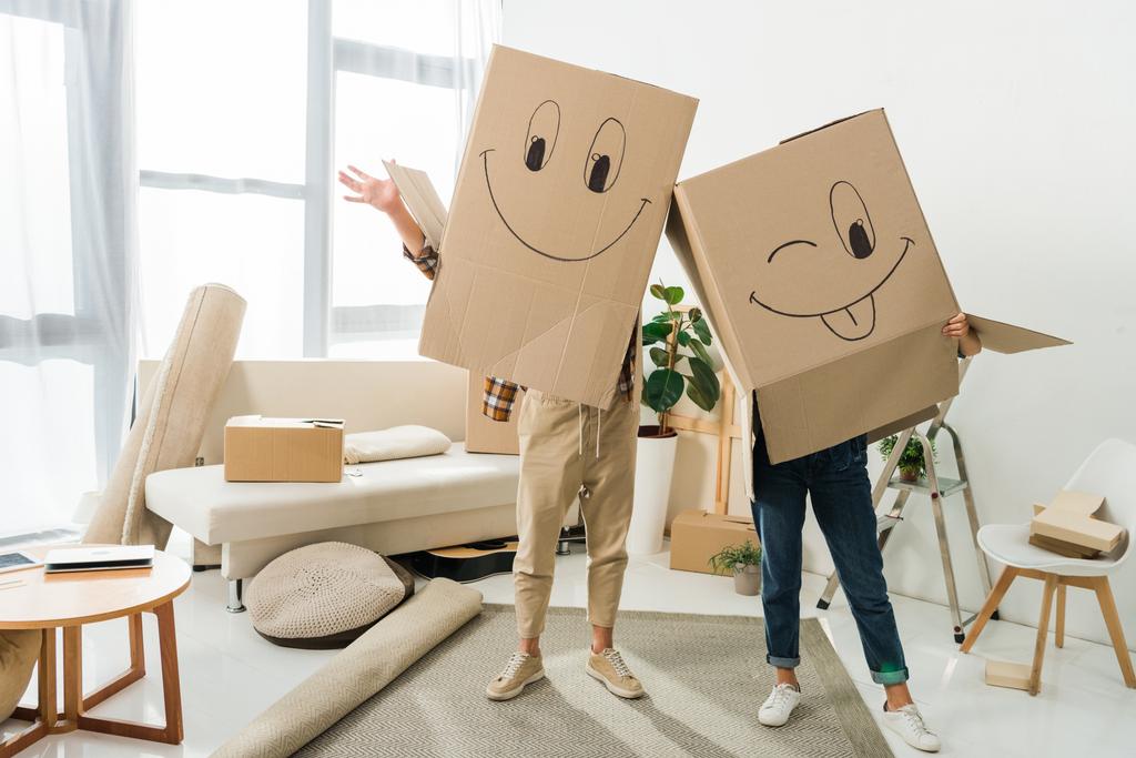 vue obscurcie du couple avec des boîtes en carton sur les têtes à la nouvelle maison, déménagement concept de maison
 - Photo, image