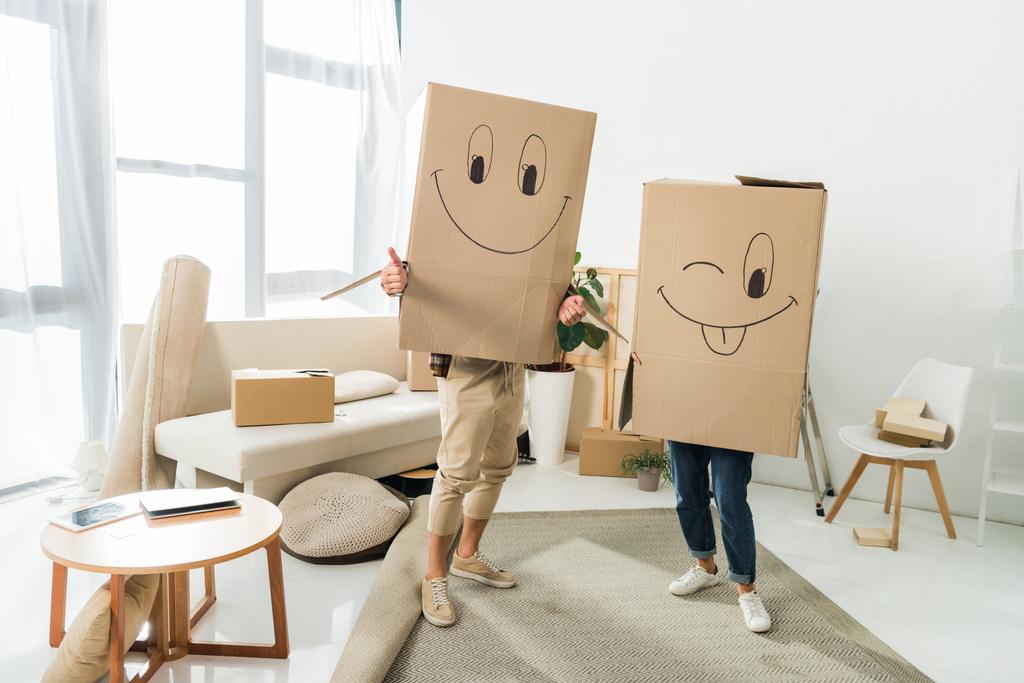 het oog wordt onttrokken weergave van paar met kartonnen dozen op hoofd op nieuw huis, bewegende huis concept - Foto, afbeelding