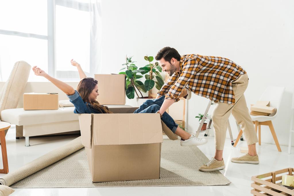 Μερική άποψη του ζευγάρι έχει τη διασκέδαση με κουτί από χαρτόνι στο νέο σπίτι, κινείται home concept - Φωτογραφία, εικόνα