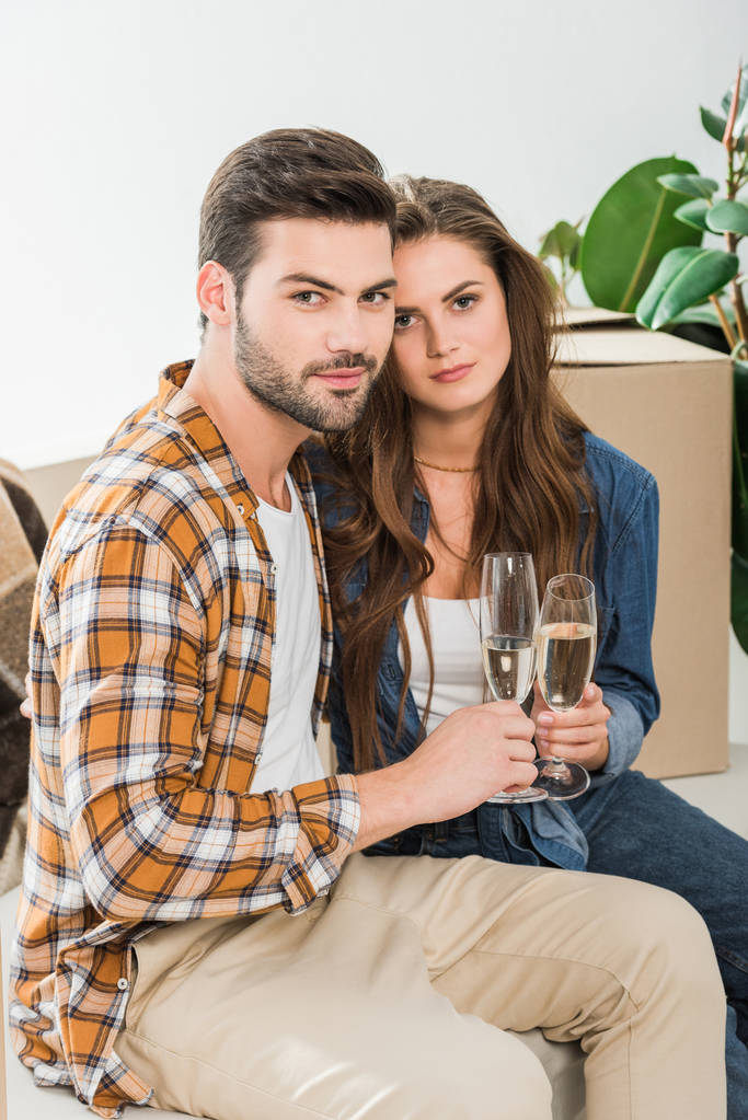 пара закохана в келихи шампанського в новому будинку з картонними коробками, концепція переїзду додому
 - Фото, зображення