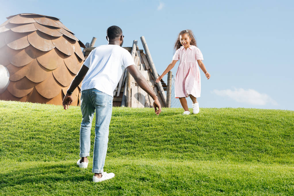 afro-americana figlia correre a padre sulla collina al parco divertimenti
 - Foto, immagini
