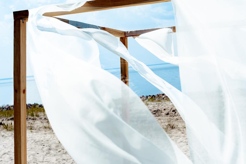 κλείνω πάνω θέα ξύλινη διακόσμηση με δαντέλα λευκή κουρτίνα, μπλε συννεφιασμένο ουρανό και ποτάμι σε φόντο - Φωτογραφία, εικόνα