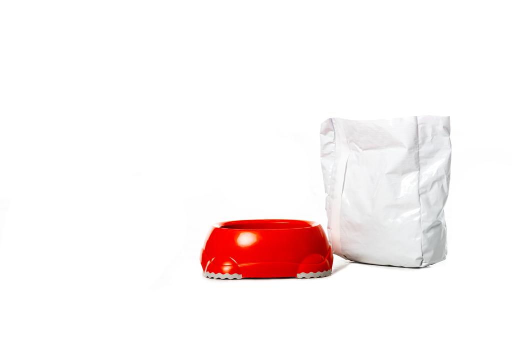 piros tál közelében csomag állateledel elszigetelt fehér background  - Fotó, kép