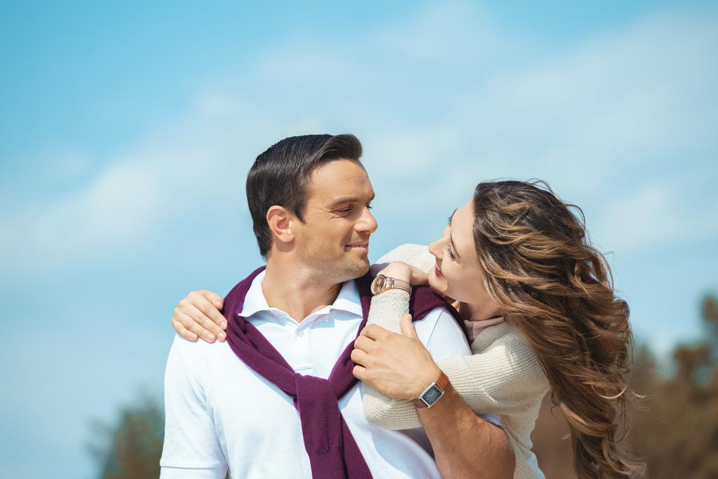 портрет веселой пары, смотрящей друг на друга с голубым небом на фоне
 - Фото, изображение