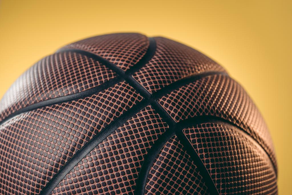 close up of brown basketball ball isolated on yellow - Photo, Image