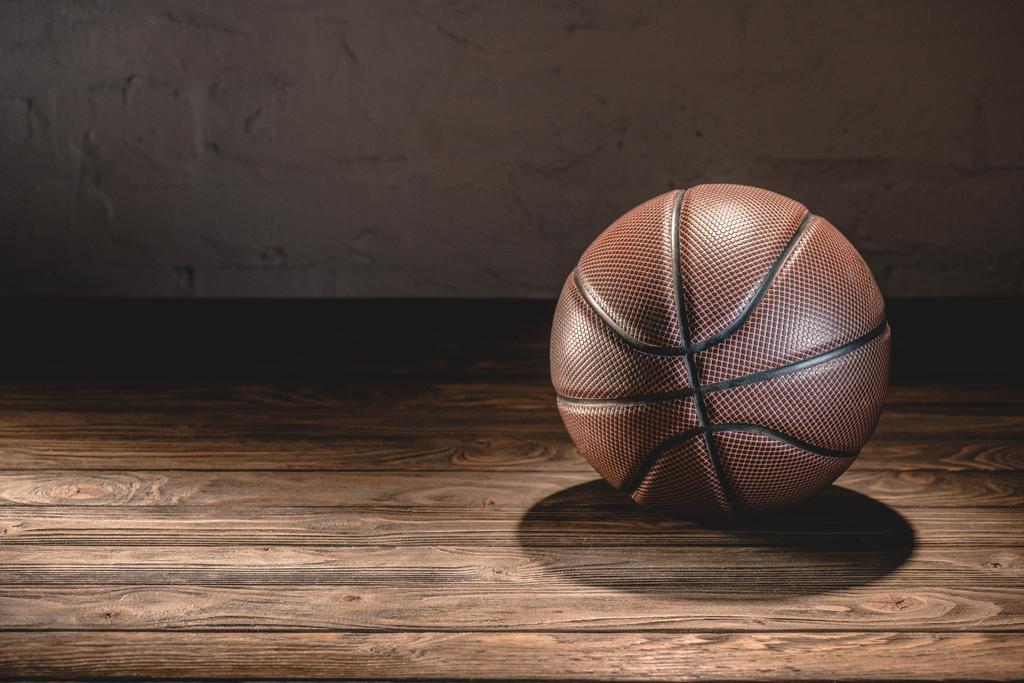 basketbal bal op houten bruine vloer - Foto, afbeelding