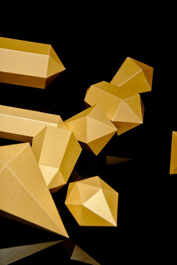 close-up view of shiny faceted pieces of gold reflected on black  - Photo, Image