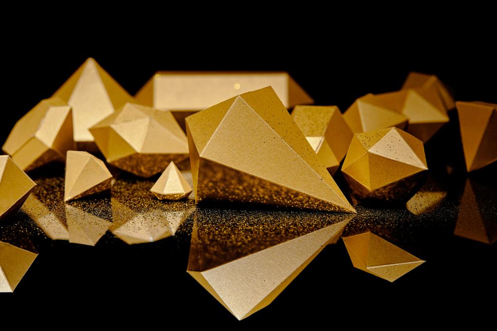 close-up view of shiny pieces of gold and golden dust reflected on black    - Photo, Image