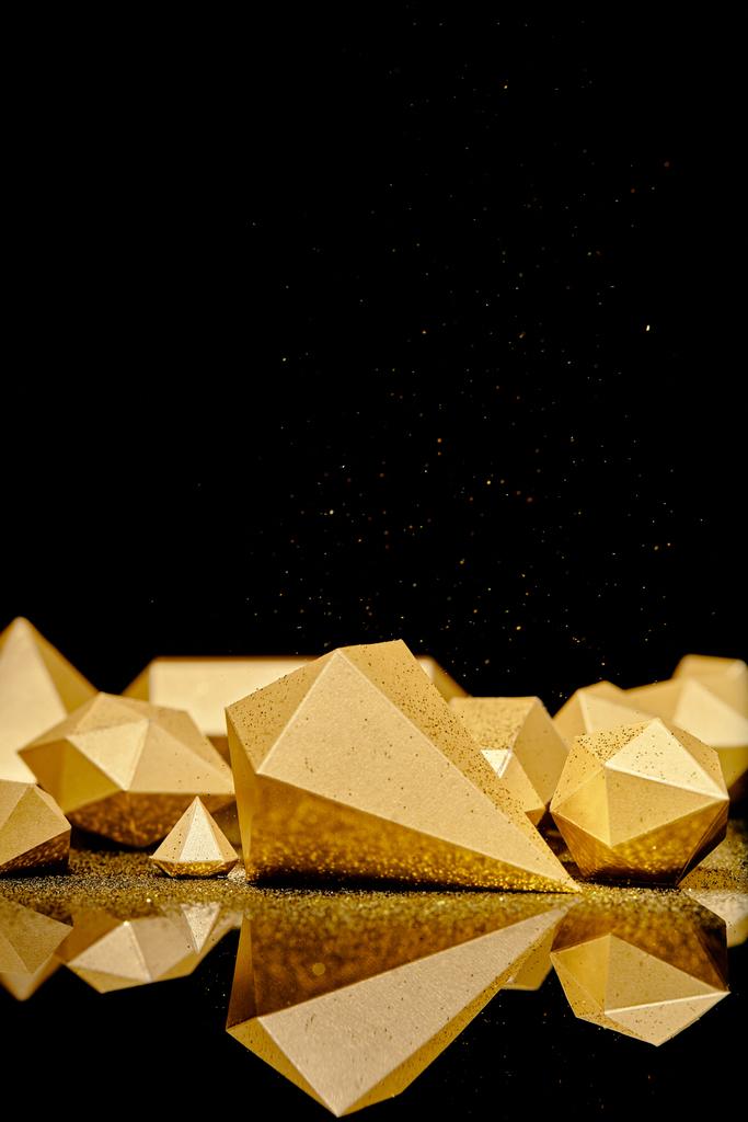 λαμπερά λαμπερά κομμάτια του χρυσού και χρυσό σκόνη αντανακλάται σε μαύρο φόντο  - Φωτογραφία, εικόνα