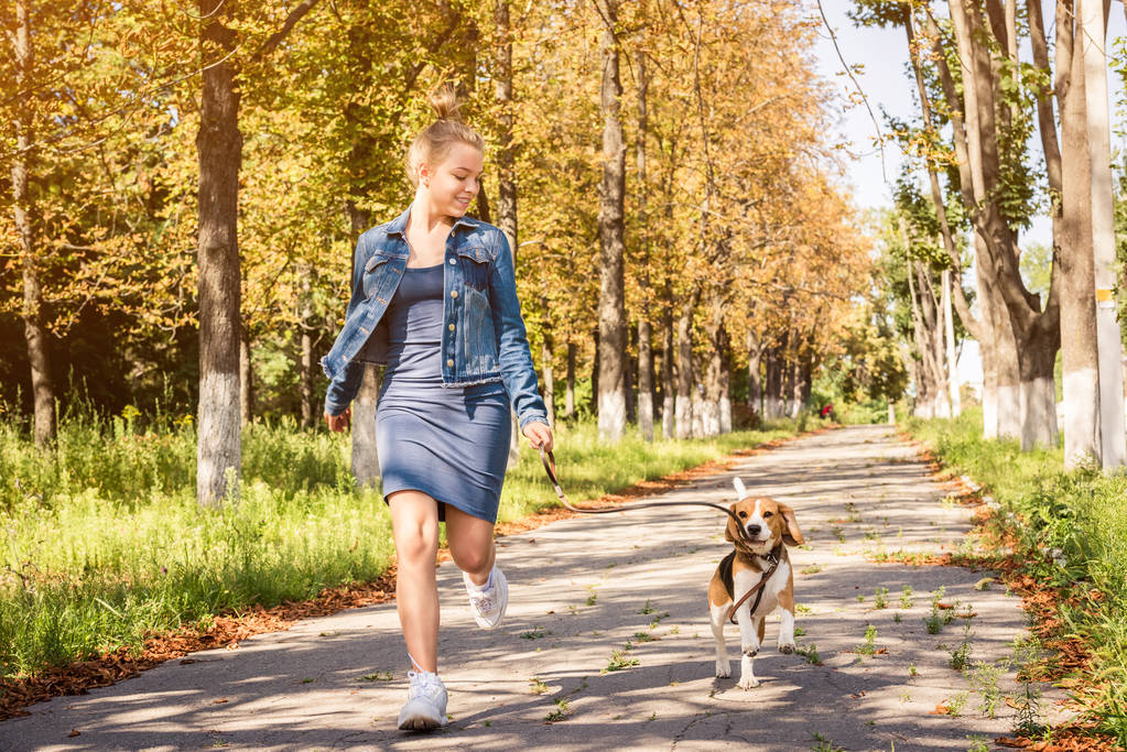 Chica rubia caminando con lindo cachorro
 - Foto, Imagen