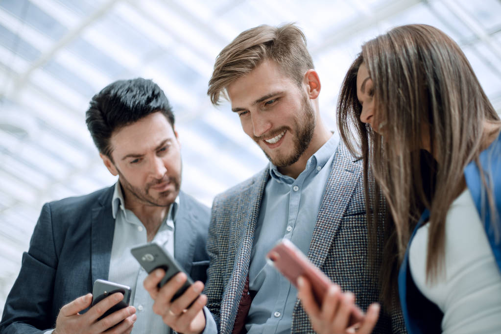 close up.business colleagues reading a text on smartphones - Photo, Image