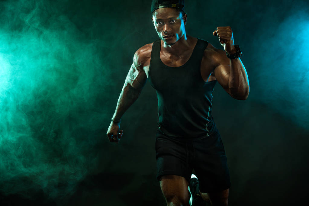 Sports wallpaper on dark background. Power athletic guy bodybuilder. Fire, smoke and energy. - Photo, Image